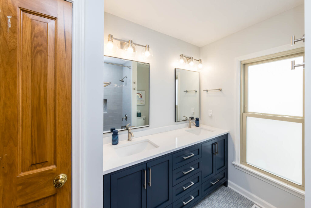 Columbus bathroom remodel with blue vanity, quartz countertop and silver faucets and hardware