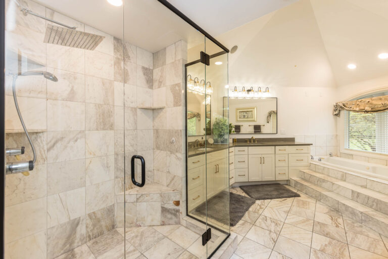 Dublin bathroom remodel with white tiled walk in shower and cream colored vanity cabinets
