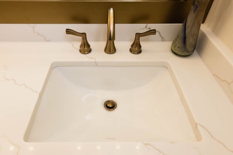 Dublin Bathroom Remodel with gold faucet and drain on quartz countertop.
